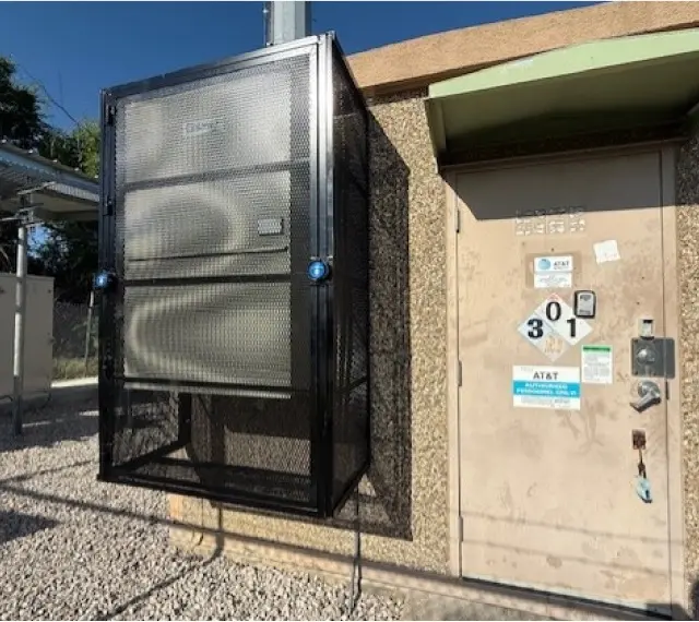 Large custom protective cage enclosure with equipment visible through mesh panels