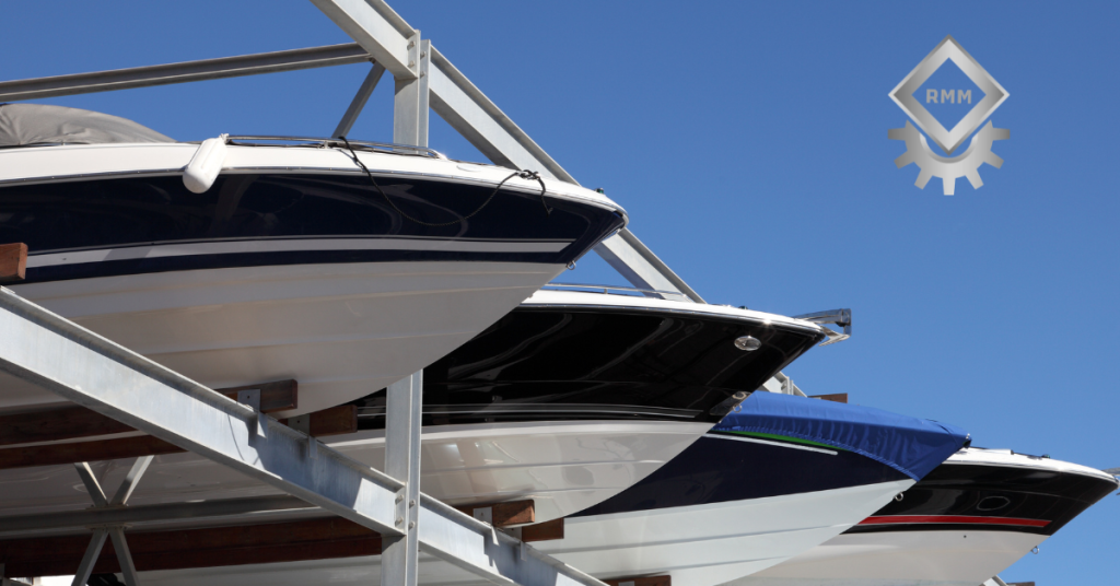 Multiple powerboats stored vertically on a heavy duty galvanized steel marina dry storage rack system under a clear blue sky