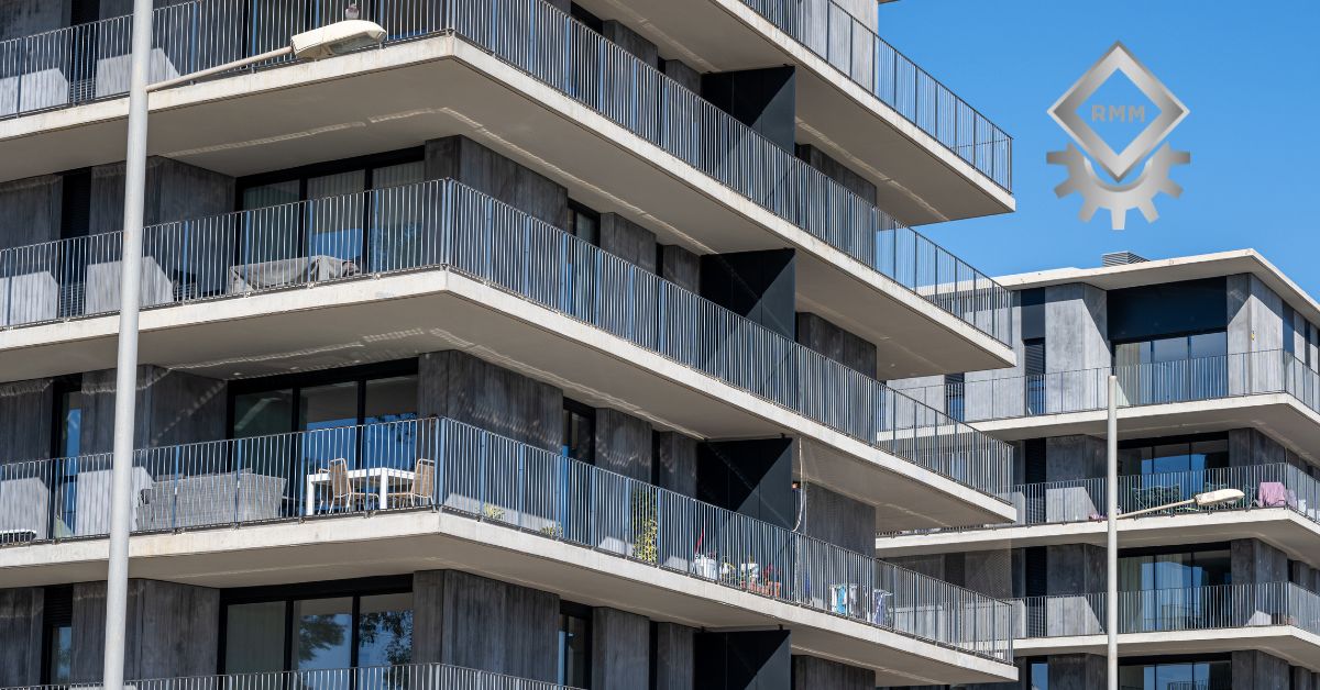 Modern multi-story condominium building featuring clean balcony lines and vertical architectural louvers under a clear blue sky