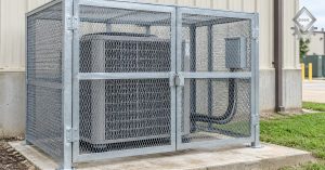 Galvanized steel security cage anchored over a commercial HVAC condenser